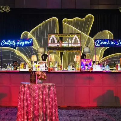 A stylish and modern bar setup from a cocktail event. The neon signs, glowing back-lit flower motif, and well-organized display show my commitment to making even functional areas a core part of the design.