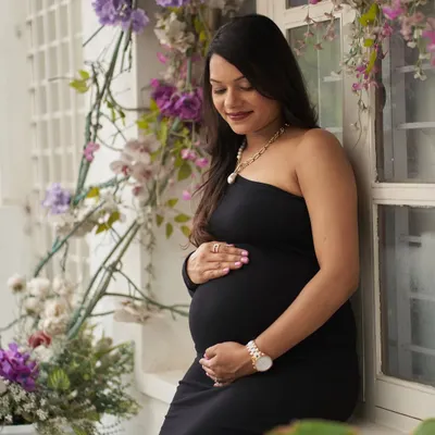 A beautiful solo portrait in our Zelda gown. This one-shoulder black dress is simple yet elegant, perfect for a classic maternity shoot.