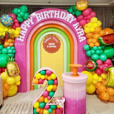 A closer look at our "Tutti Frutti" theme, featuring a multi-layered rainbow arch, a custom marquee number prop, and a colorful ombre-style plinth for the cake.