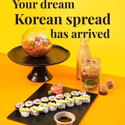 Your dream vegetarian Korean spread has arrived. This shot captures a complete meal I offer, including a platter of my fresh vegetable and avocado sushi, a Bibimbap Noodle Jar, and a refreshing drink. It's a vibrant and healthy feast.
