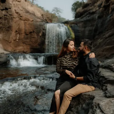 A quiet moment of connection for this couple, set against the raw beauty of a waterfall. These natural settings provide a powerful backdrop for pre-wedding photography.