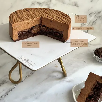 The anatomy of my Chocolate Dream Entremet. It features a chocolate sable base, moist chocolate sponge, a crunchy feuilletine layer, and is topped with a light, airy chocolate mousse.