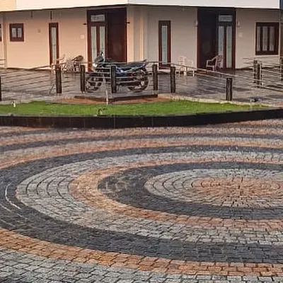 A finished driveway using a circular pattern of multi-colored cobblestones. This shows the beautiful designs you can create.