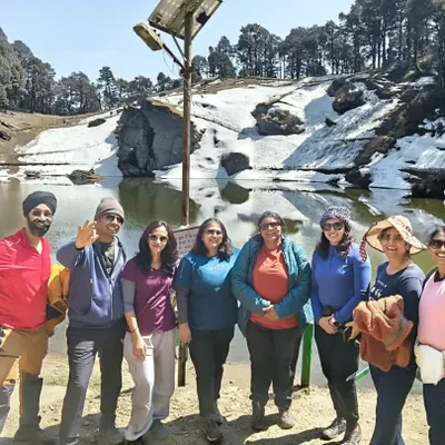 Our group at a snow-covered lake during the Jibhi & Tirthan Valley trip in the Himalayas.