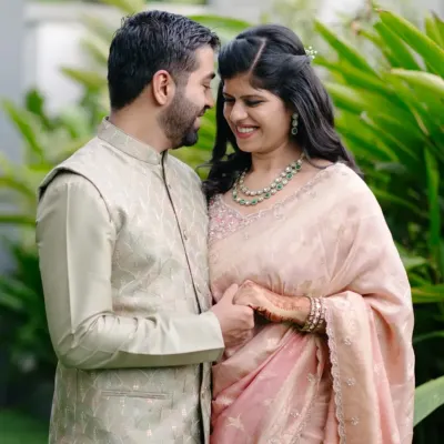 A lovely, candid portrait from an engagement day shoot. The natural green background makes their traditional outfits pop, and their gentle smiles show the happiness of the occasion.