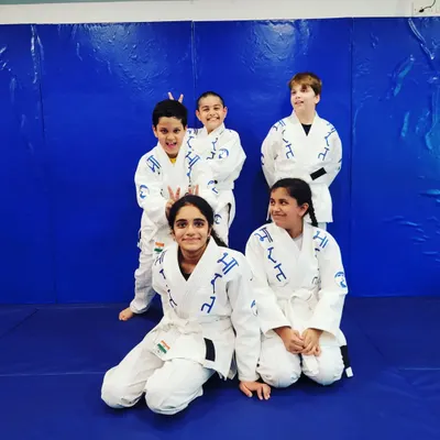 The Jiu-Jitsu squad. In their gis, these kids learn to work together, trust each other, and have fun on the mats. This is where friendships are built.