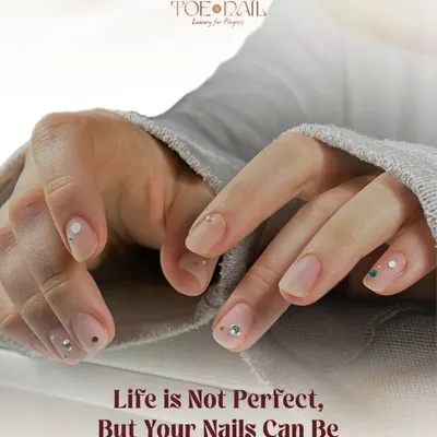 A subtle and elegant design featuring a natural-looking manicure with tiny, strategically placed rhinestones. This shows how a little bit of 3D sparkle can elevate a simple look.