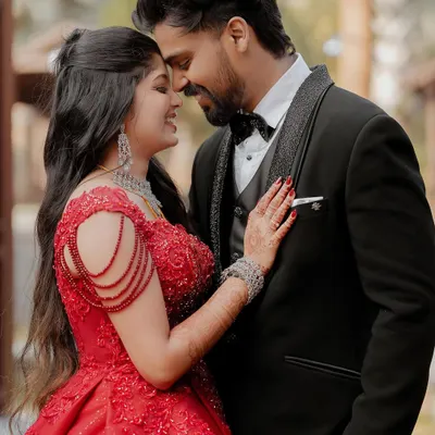 A fairytale moment from the reception. The bride in her stunning red ball gown and the groom in his classic tuxedo share an intimate embrace, full of modern romance.