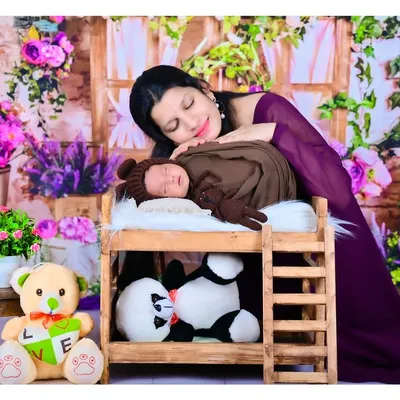 This image captures the tender bond between a mother and her newborn. My studio is equipped with adorable props like this miniature bed and soft wraps to create a dreamy and safe setting for your baby's first photoshoot.