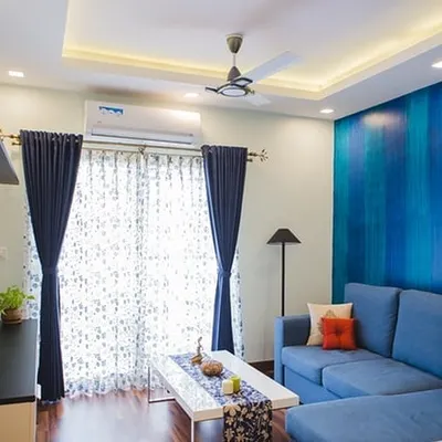 A vertical striped texture effect in shades of blue creates a simple yet effective accent wall in this living room. This technique can make a room feel taller and adds a touch of modern elegance.