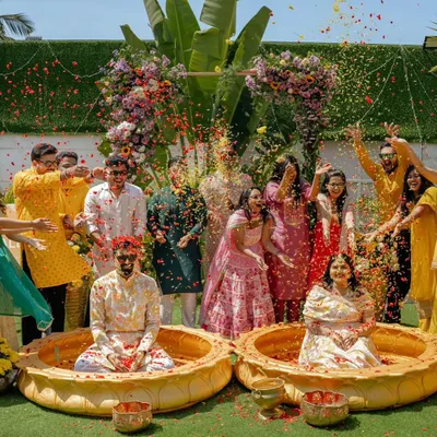 The pure, uninhibited joy of a Haldi ceremony. I created this fun outdoor setup with large lotus-shaped urlis for the couple, surrounded by their loved ones showering them with flower petals.