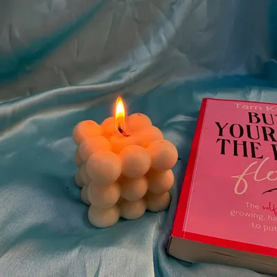 My modern bubble candle, lit and creating a warm glow. It's infused with a calming lavender scent, making it a perfect addition to your reading nook or self-care routine.