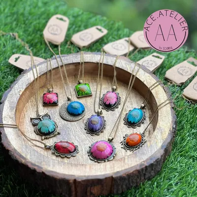 A beautiful collection of vintage-style floral pendants. Each one features a real dried flower preserved in resin, making every piece unique.