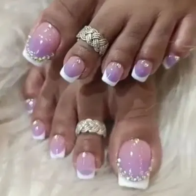 A close-up of our detailed pedicure art, featuring a purple and white ombre with a border of tiny rhinestones on the big toe.
