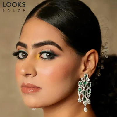 A striking party look featuring a pop of color. I used a teal and yellow eyeshadow combination for a unique and modern feel, paired with dramatic lashes and a glossy nude lip to keep the focus on the eyes.