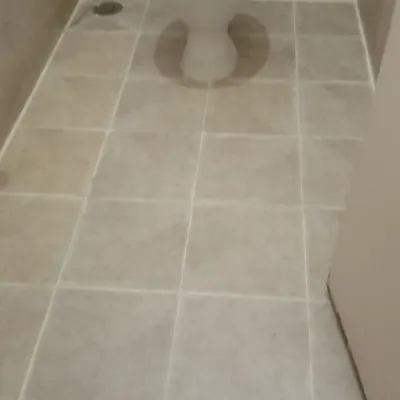 A fully grouted and waterproofed bathroom floor, including around the Indian toilet fixture. My precise work ensures a complete seal in these high-moisture areas, preventing leaks to floors below.