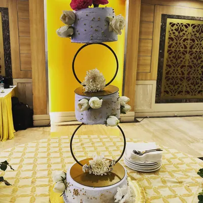 This three-tier floating wedding cake is a true showstopper. We designed this lilac and gold masterpiece to be as magical as the special day itself, complete with fresh flowers and delicate details for an elegant celebration.
