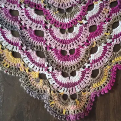 A close-up detail of the famous Virus Shawl pattern. You can see the repeating shell stitches that create the signature "viral" spread, which looks so beautiful with self-striping yarn.