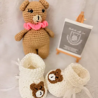 This adorable combo set includes a 6-inch amigurumi bear and a matching pair of bear-themed booties, making it a perfect gift for a newborn.