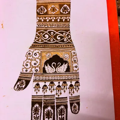 We start by learning to draw classic motifs, like this elegant swan design. Practicing on paper helps you perfect the shapes and shading before you apply the mehndi cone to the skin.