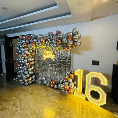 This glam party backdrop features a silver shimmer wall that catches the light beautifully. We framed it with a modern balloon arch in metallic silver and rose gold, complemented by a "Happy Birthday" neon sign and large marquee numbers.