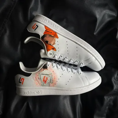 A pair of custom Adidas Stan Smiths for a McLaren F1 fan, featuring driver Lando Norris and his LN4 logo.
