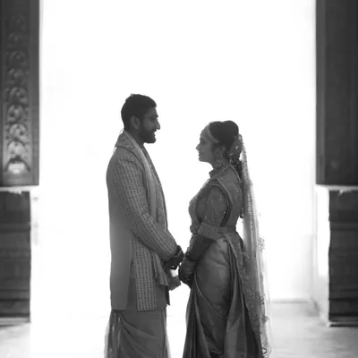A silhouette against a stark white background. This high-contrast, minimalist black and white portrait focuses on the couple's connection and the space between them, creating a powerful, artistic statement.