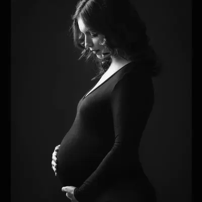 A classic black and white portrait that uses soft light to sculpt the beautiful curves of pregnancy. It's minimal, powerful, and timeless.