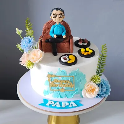 A full view of the personalized cake for "Papa," featuring his edible miniature relaxing on a custom-made fondant armchair. The entire scene, including the cake and toppers, was designed to celebrate him in a unique and heartfelt way.