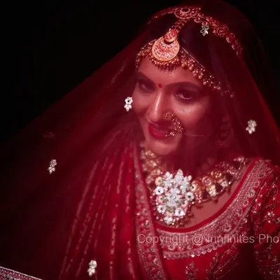 The bridal veil adds an element of mystery and elegance. I used dramatic lighting to create this stunning, moody portrait that highlights the bride's intricate jewelry and the rich color of her veil.
