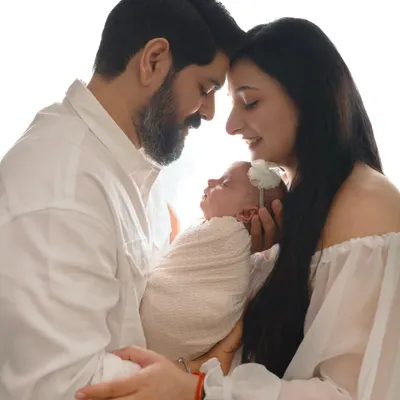 A beautiful silhouette of new parents touching foreheads while holding their newborn baby. These high-contrast, emotional shots are some of my favorites.