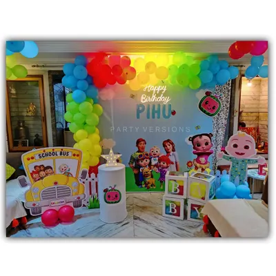 A complete Cocomelon birthday theme setup for Pihu's party at home. This includes a colorful backdrop, character cutouts, a balloon garland, and even a themed school bus prop.