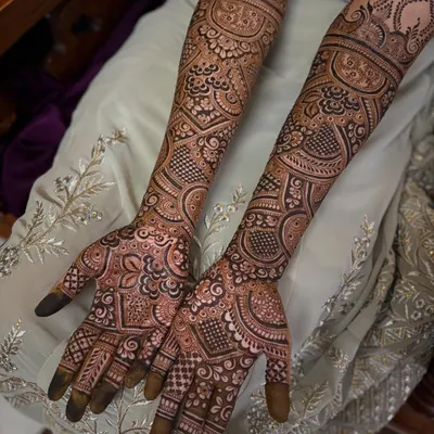 A complete view of a full bridal mehendi in the Pakistani style. Notice how the patterns flow from the fingertips all the way to the elbows, creating a seamless and intricate sleeve of henna.