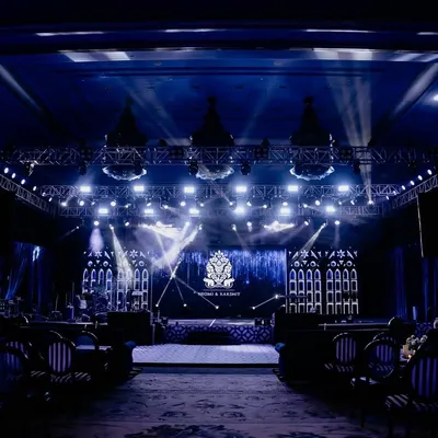 The main stage for Neomi and Rakshit's 'Gothic Palace Ball' Sangeet. The dramatic lighting, large LED screen with a custom monogram, and Gothic-inspired side panels created a spectacular setting for the night's performances.