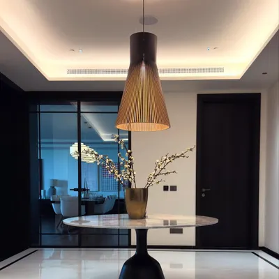 A minimalist foyer table designed to make a statement. The piece features a pure white marble top on a sculptural black pedestal base, creating a beautiful contrast on the polished marble floor.