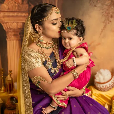 A mother's tender kiss for her little Krishna. This close-up shot is full of emotion, set against a rich, traditional backdrop that brings the Janmashtami theme to life.