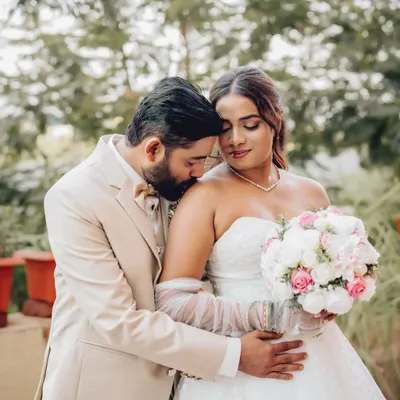 A tender moment between the groom and bride, captured outdoors. This intimate wedding portrait highlights the couple's connection in a natural setting.