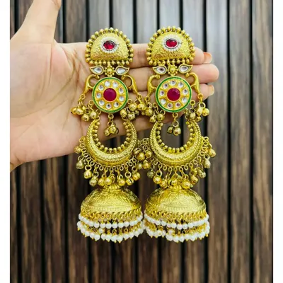 A stunning pair of gold-plated chandbali jhumkas with red and green meenakari work and pearl details. These are perfect for adding a touch of royalty to any ethnic outfit.