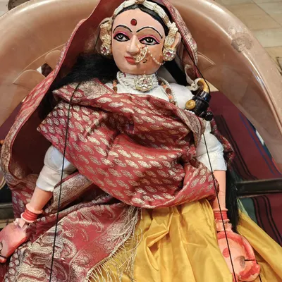 A beautifully adorned female puppet, possibly a queen or a goddess, showcasing the intricate jewelry, costume, and expressive features that are a signature of our work.