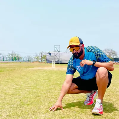 On the field, inspecting the pitch. Understanding the playing surface is a critical part of cricket strategy, a detail I emphasize in both my coaching and commentary. This is where the game is won or lost.