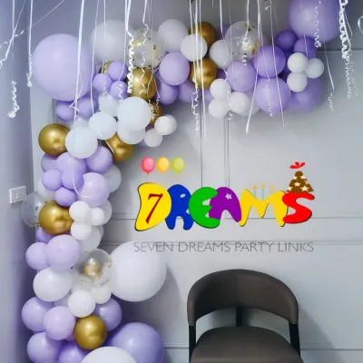 A beautiful balloon arch for a baby shower at home. This arrangement uses pastel purple, white, and gold balloons to create an elegant photo corner.