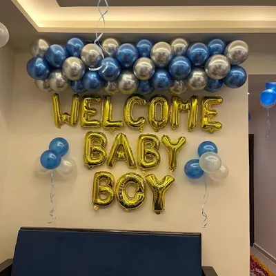 A classic and simple wall decoration to welcome a baby boy. This setup includes "WELCOME BABY BOY" foil balloons in gold, with a garland of chrome blue and silver balloons on top. It's a quick and affordable option.
