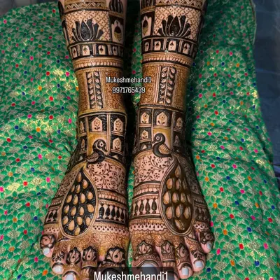 A stunning example of full bridal feet mehndi. This design features majestic peacocks and intricate architecture, creating a look of pure royalty.