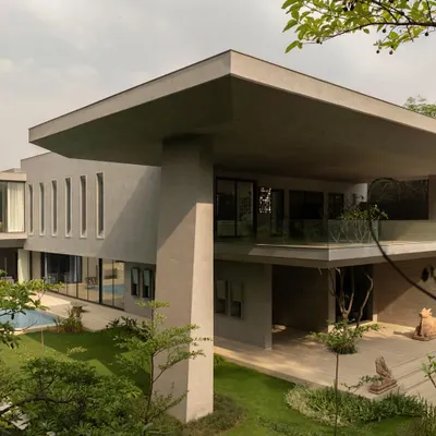An overall view of the House Around the Oblique Column, showcasing its monumental scale and the dramatic cantilevered roof. The structure is a composition of bold, intersecting geometric planes.