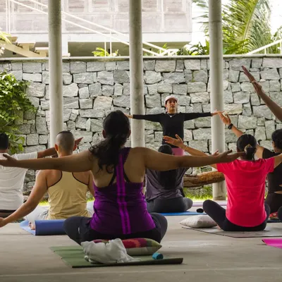 A Pilates retreat is a chance to connect with your practice on a deeper level. Here, I am guiding participants through a seated stretch, with everyone moving in unison against a backdrop of nature.
