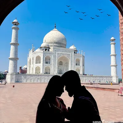 A classic silhouette against the Taj Mahal, framed by the archways. This artistic shot uses light and shadow to create a powerful, romantic image that feels both private and grand.