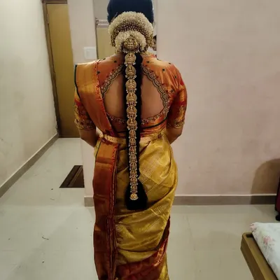 A stunning view of the complete traditional bridal hairstyle, adorned with our temple-style 'Jade Bangara' (hair braid ornament) and fresh flowers. This is the perfect finishing touch for a South Indian bride.