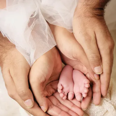 Sometimes the most powerful photos are in the tiny details. I love capturing shots like this, with a newborn's perfect little feet held securely in their parents' hands. It’s a beautiful symbol of family and protection.