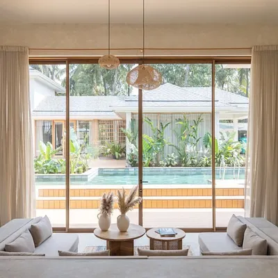 The sunken living room in the "House of Basho" is one of our favorite spaces, designed to connect you to the ground and the outdoors. Large glass panels frame a perfect view of the pool and garden, making the landscape the primary focus.