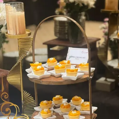 A little bite of sunshine. These mini mango cheesecakes are a seasonal favorite, served on individual star shaped plates and displayed on a rustic two tiered stand.